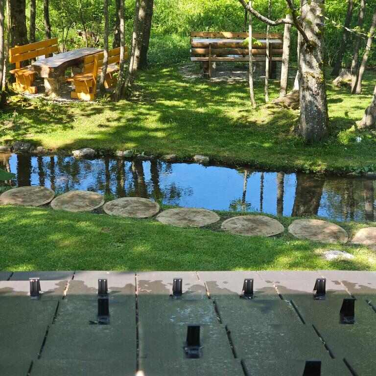 Garden with stream, stepping stones and picnic tables